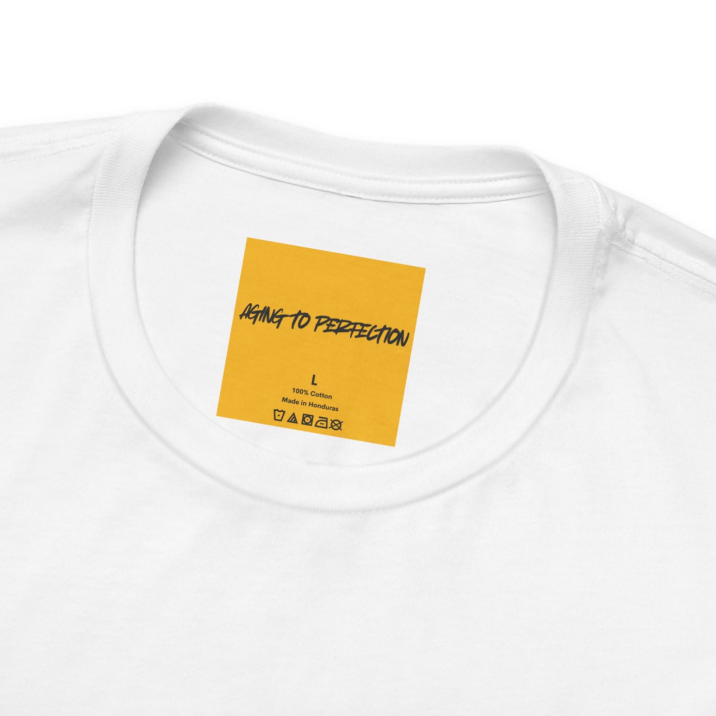 close up of yellow neck label AGING TO PERFETION on white tee