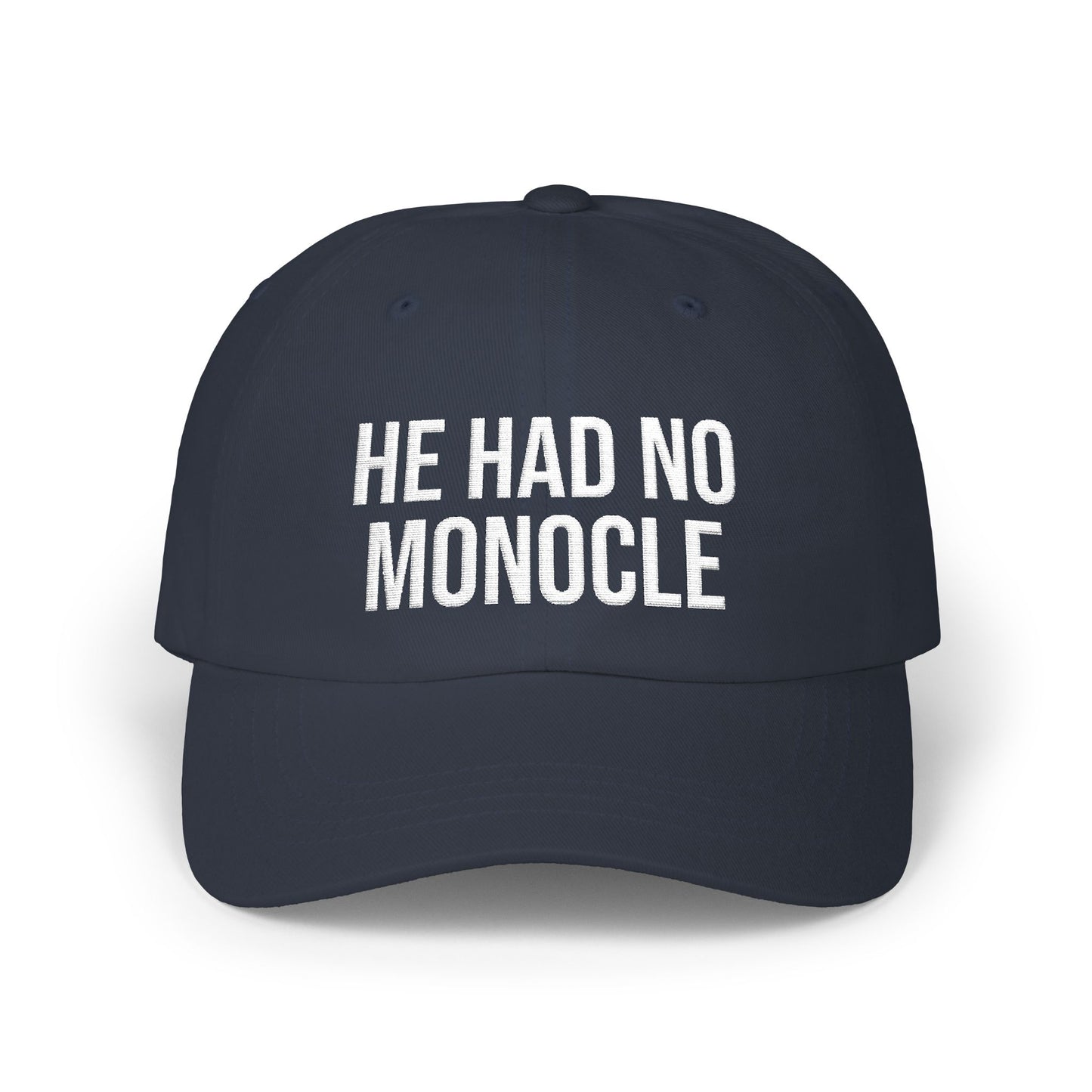 Navy blue cap with white text 'HE HAD NO MONOCLE' on a white background