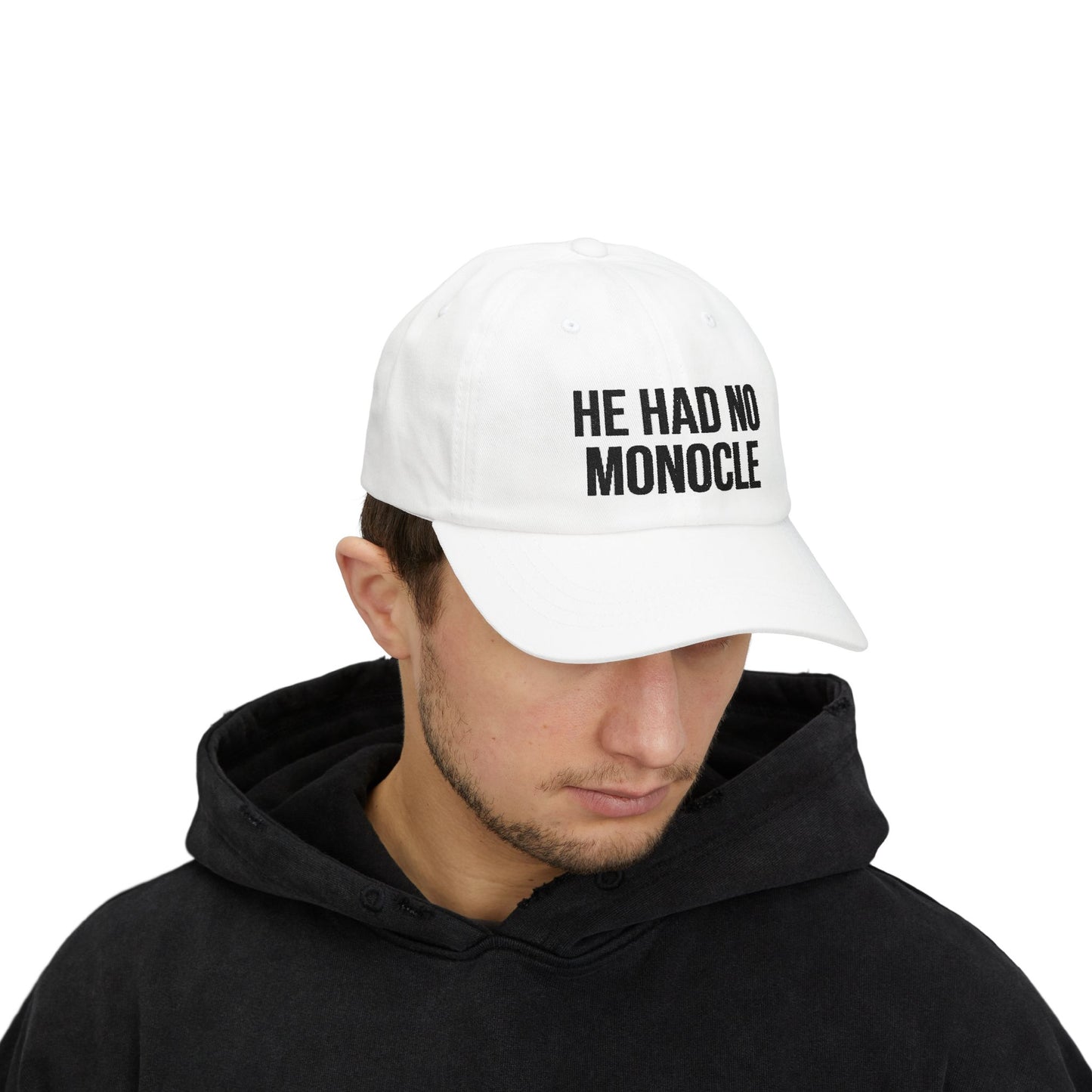 Person wearing a white cap with 'HE HAD NO MONOCLE' text on a white background