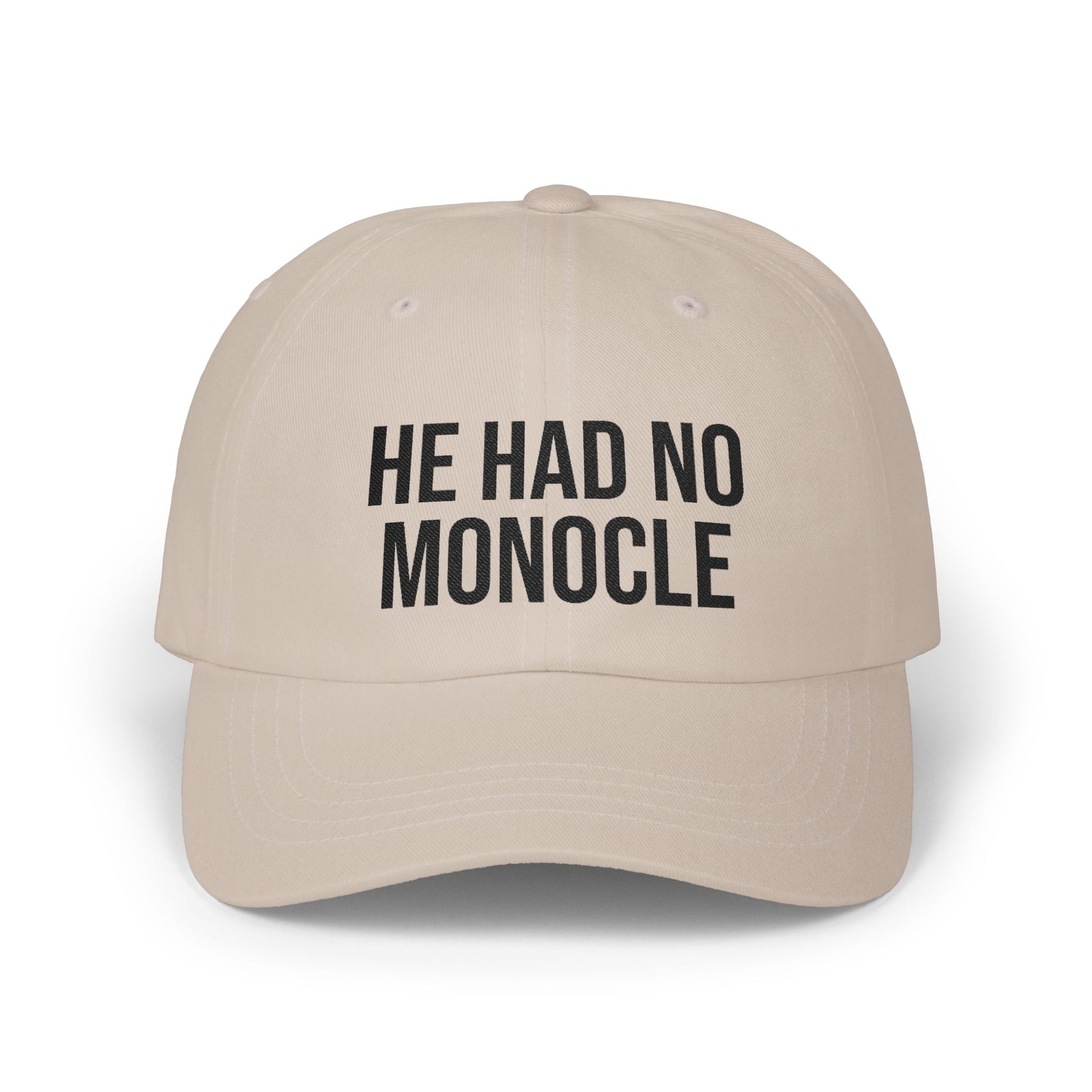 Beige cap with black text 'HE HAD NO MONOCLE' on a white background
