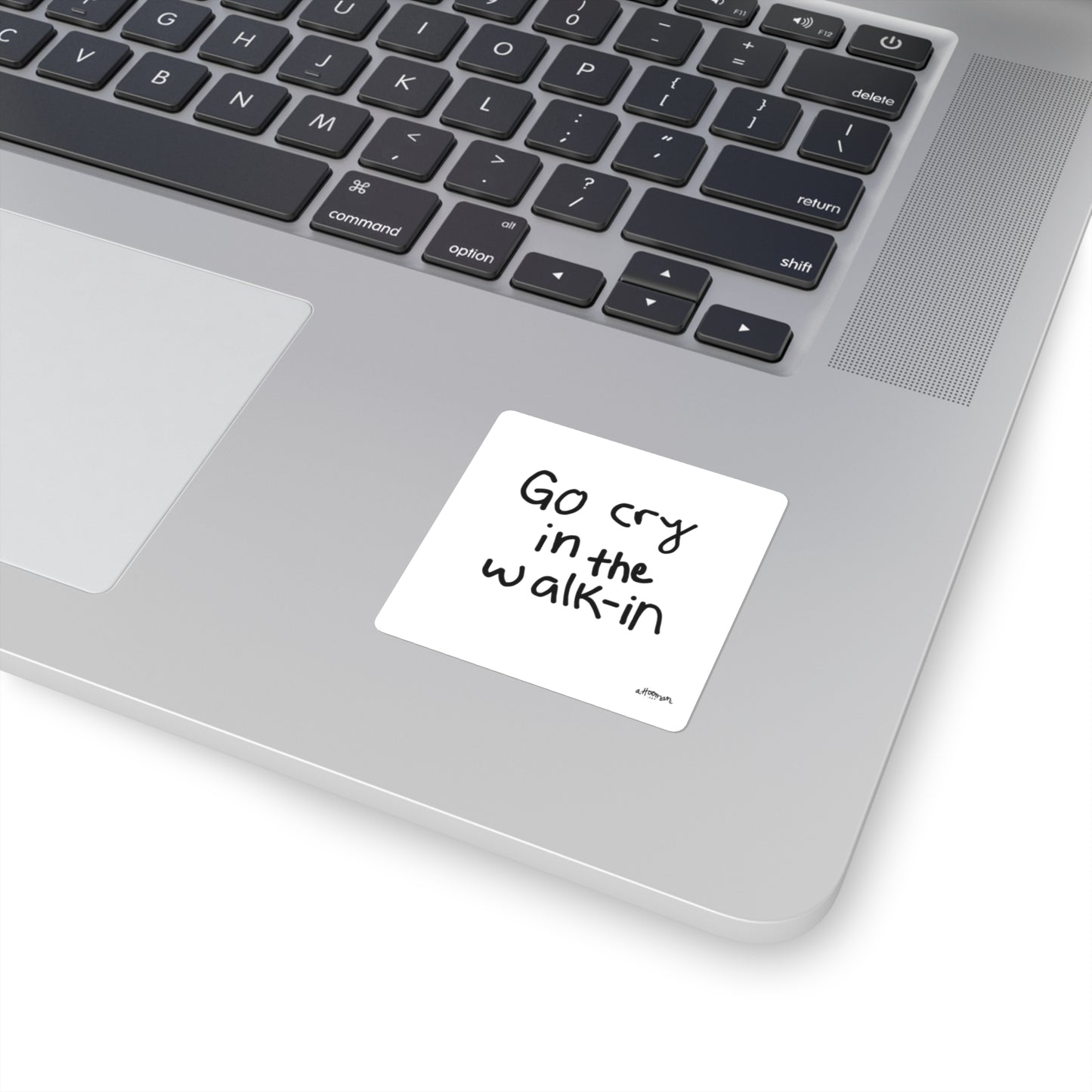 Laptop with a sticker reading 'Go cry in the walk-in' on the palm rest area.