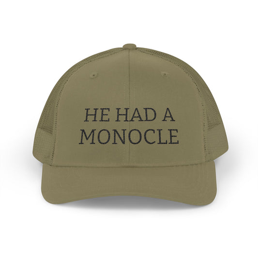 Khaki cap with 'HE HAD A MONOCLE' text on a white background