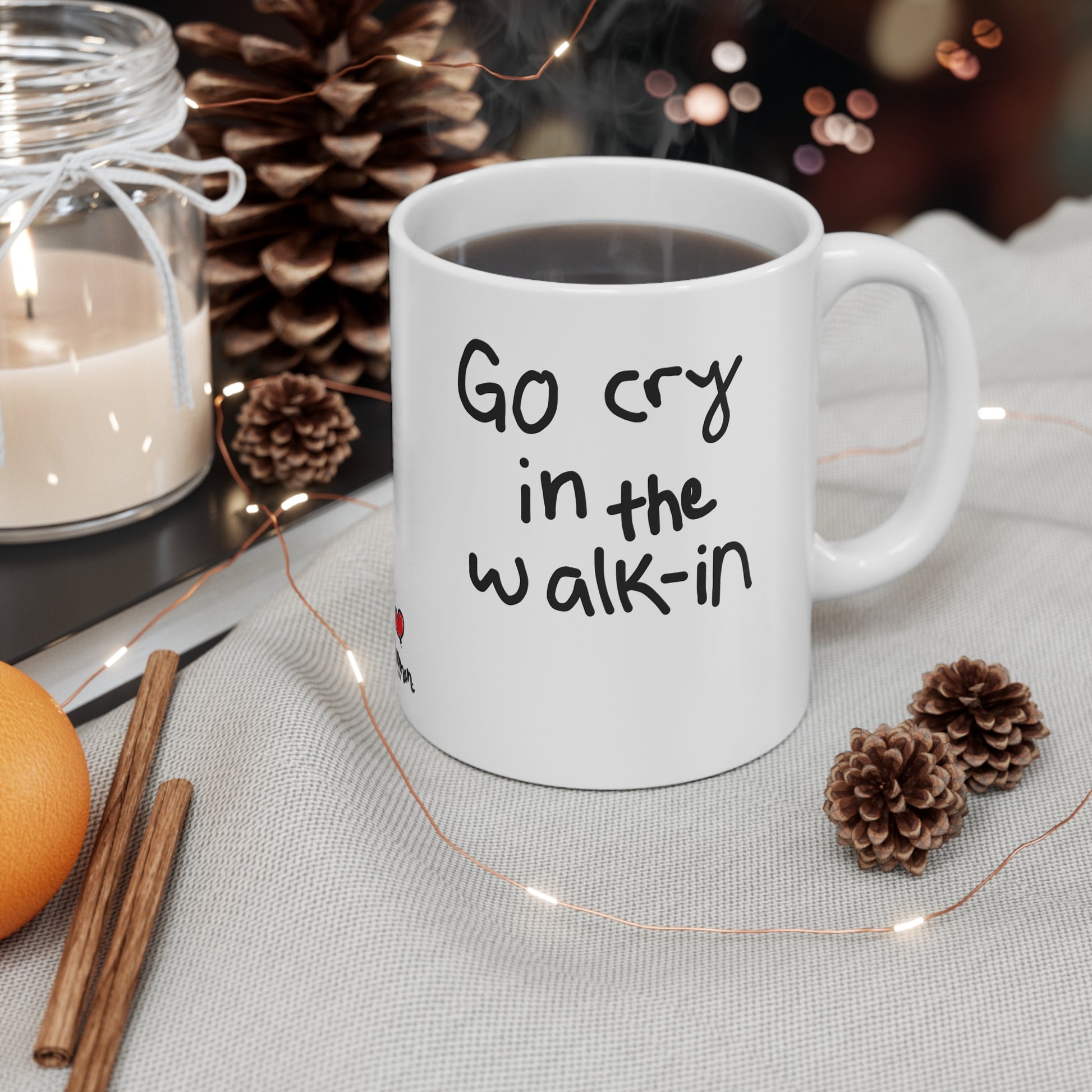 White mug with humorous text on a table with decorative items