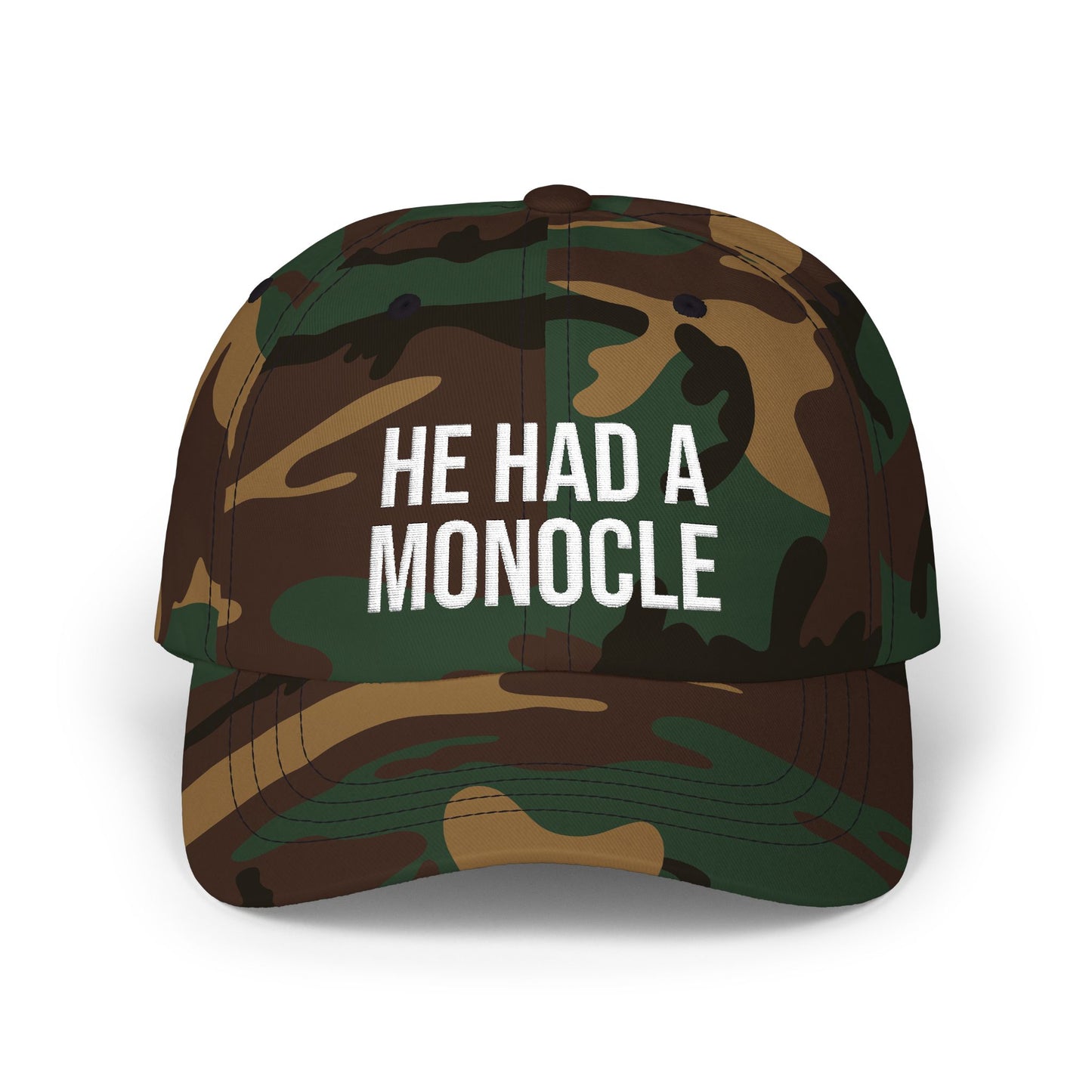 Camouflage cap with 'HE HAD A MONOCLE' text on a white background