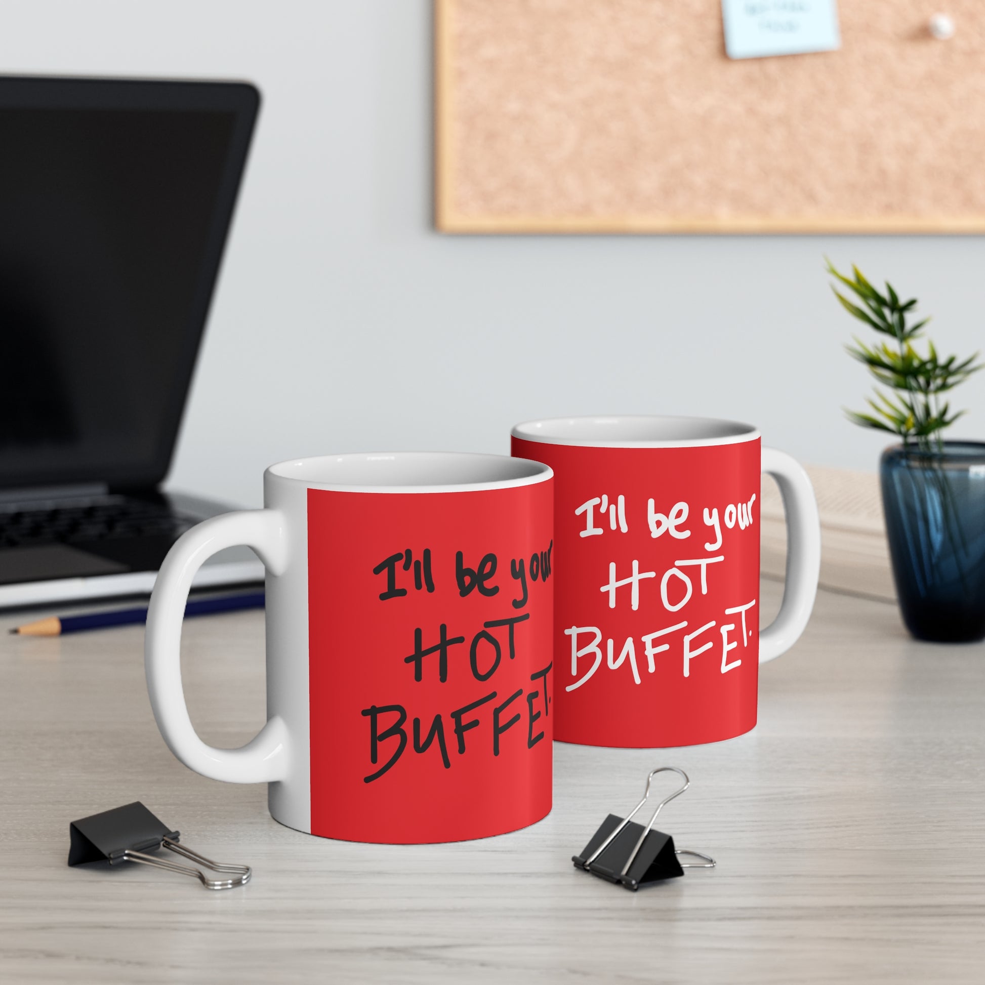Two red mugs with humorous text on a desk with office supplies.