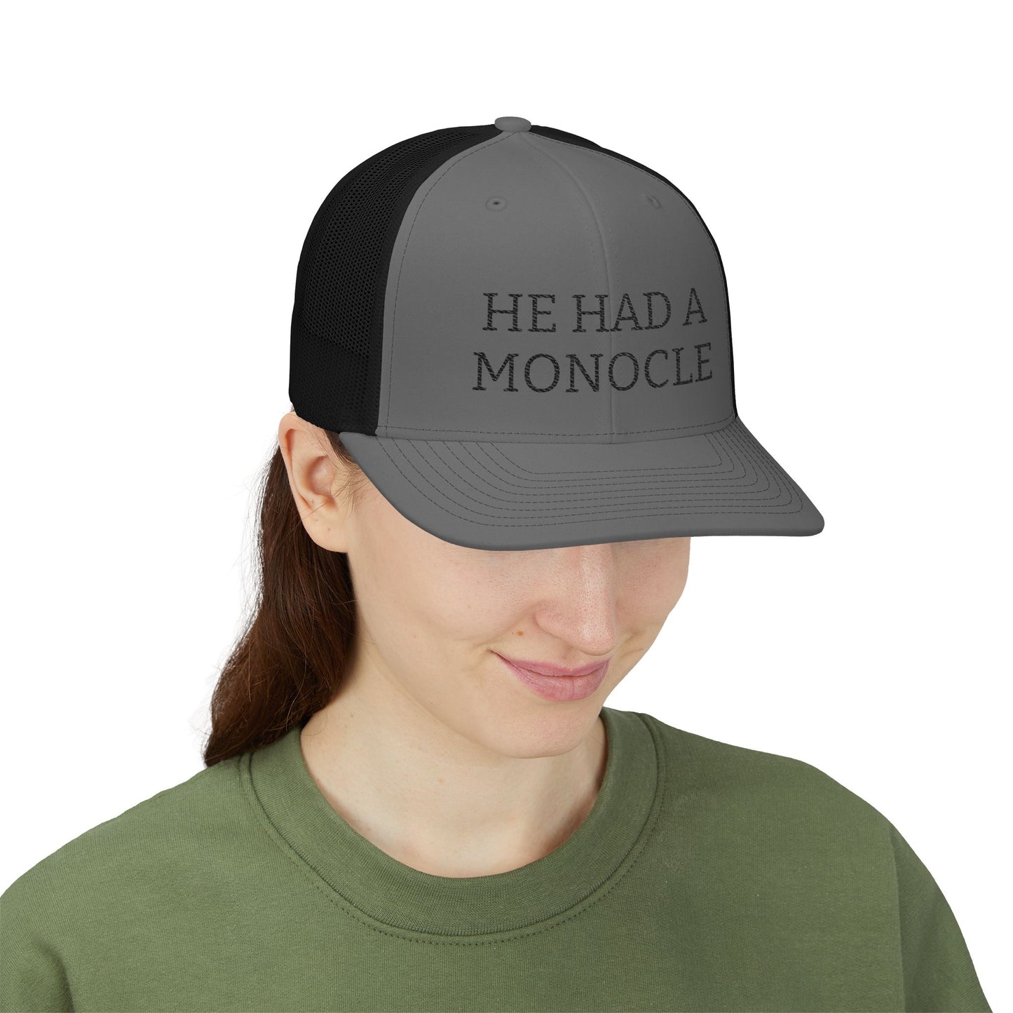 Person wearing a cap with 'HE HAD A MONOCLE' text on a white background