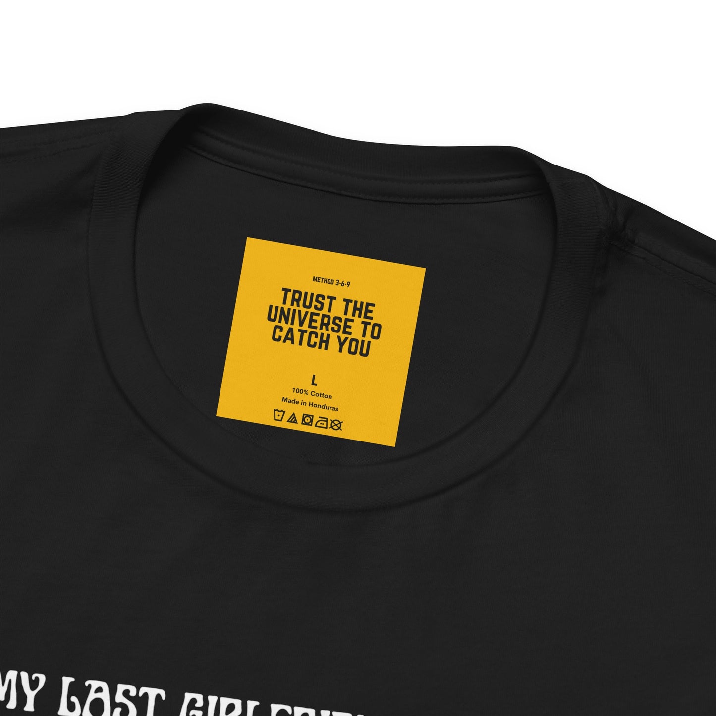 trust the universe to catch you  yellow neck label on black t-shirt