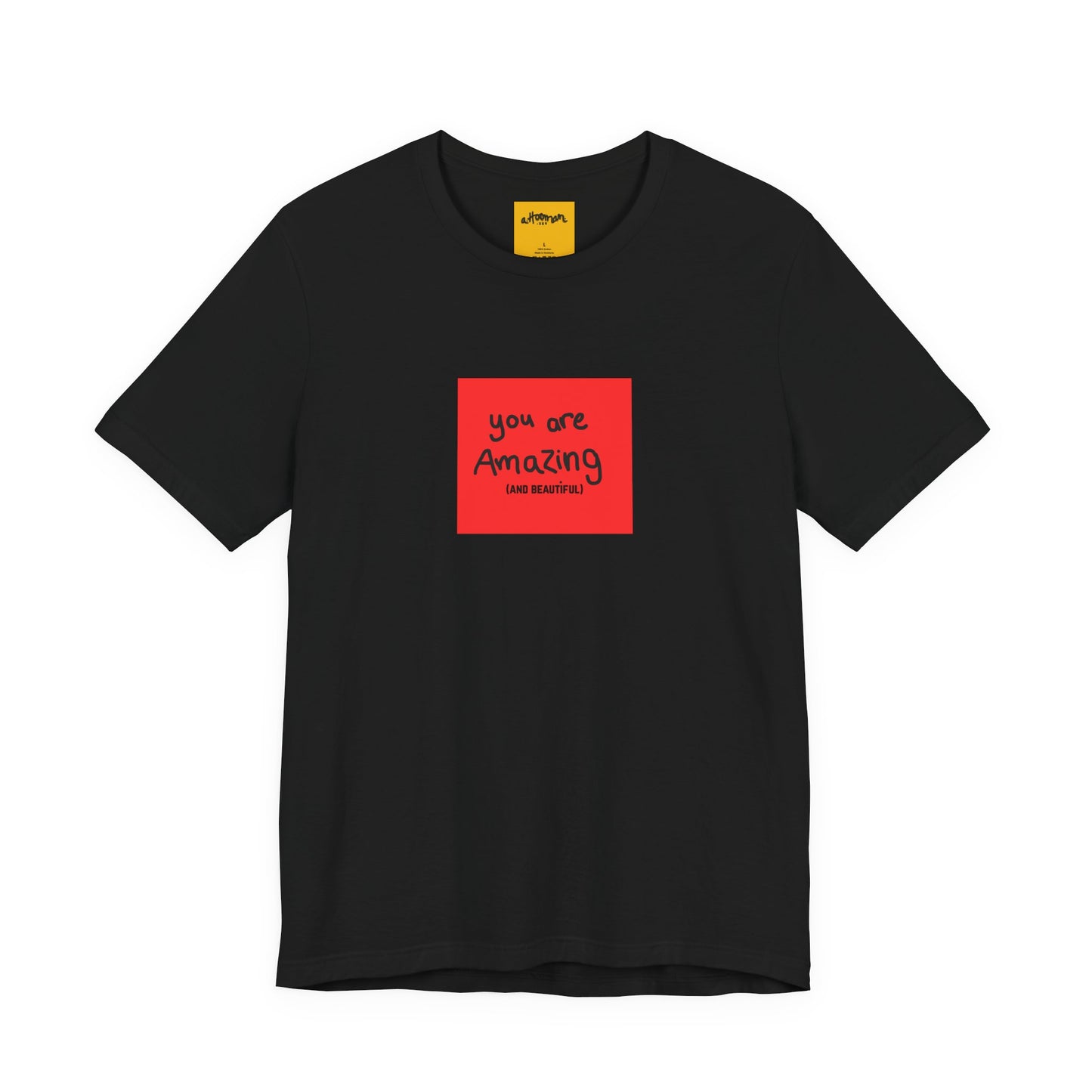 black t-shirt with a red square and text  reads you are amazing and beautiful on a white background