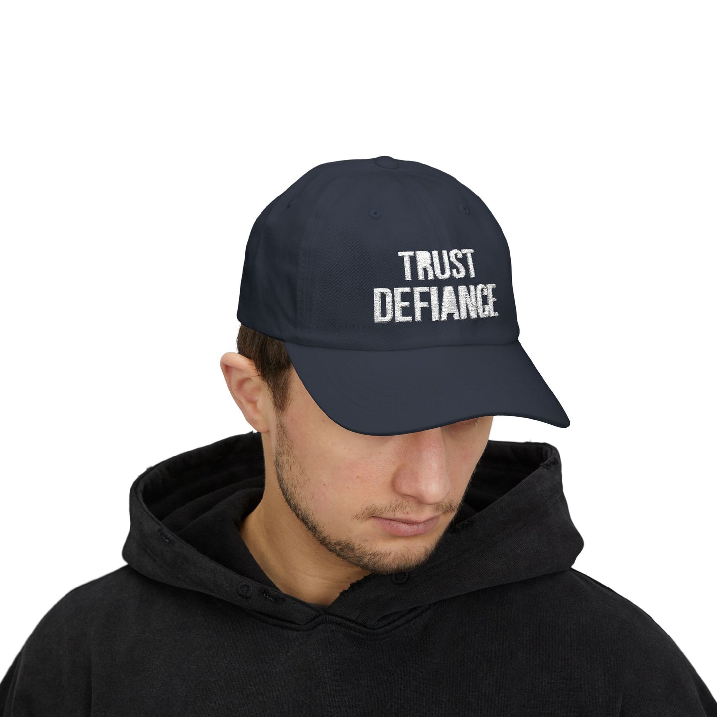 person wearing navy classic dad cap with white embroidered TRUST DEFIANCE text - unstructured cotton hat