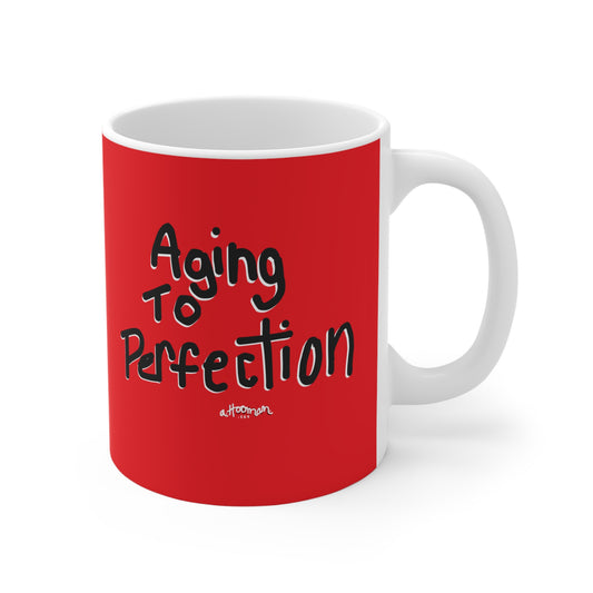 Red mug with 'Aging to Perfection' text on a white background