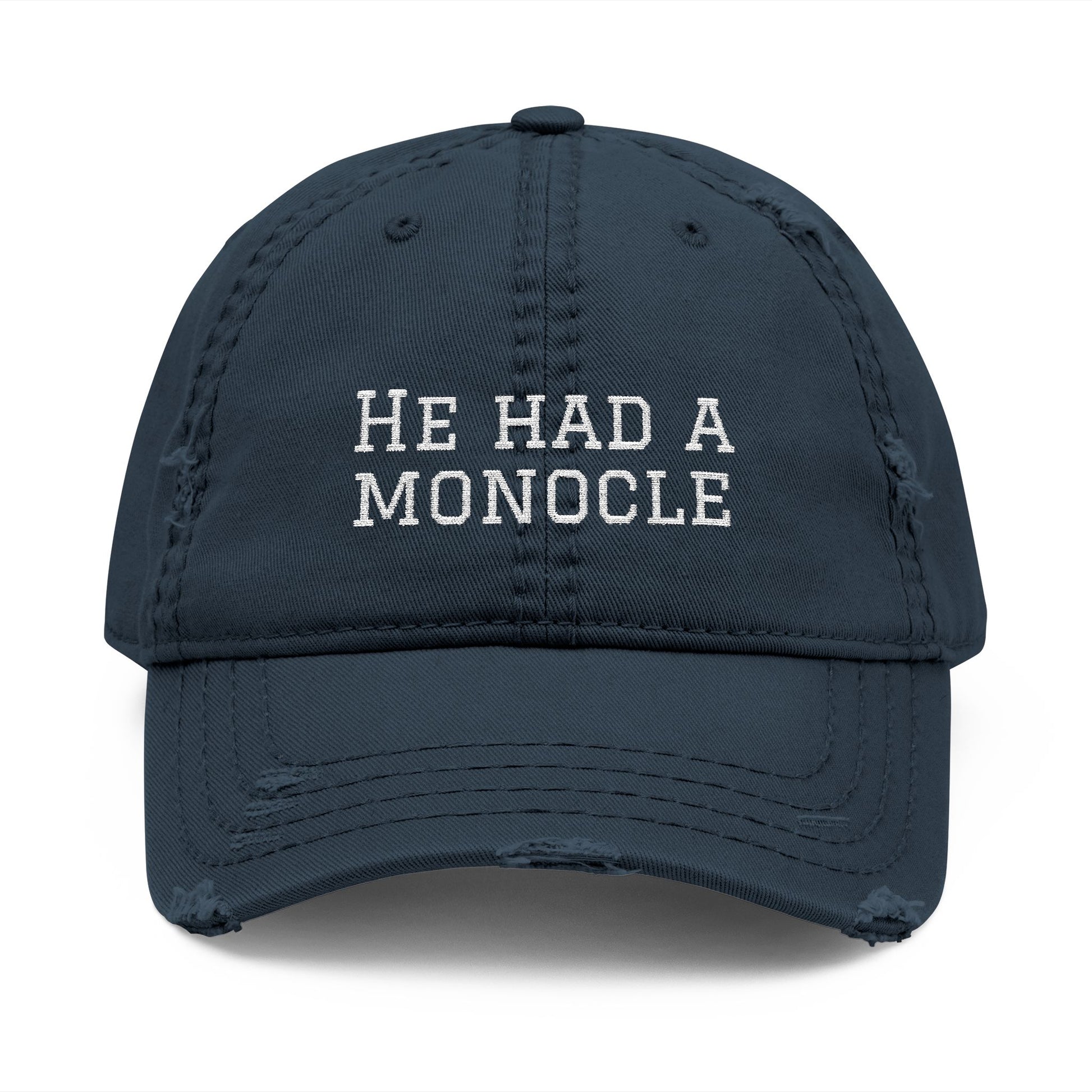 Navy blue cap with 'HE HAD A MONOCLE' text on a white background