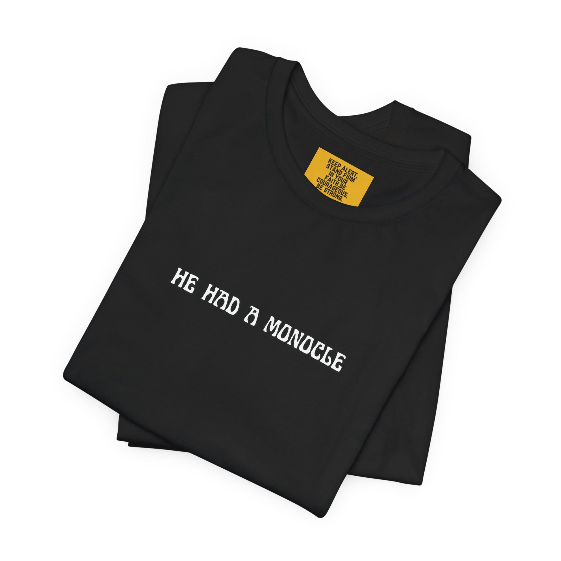 Black t-shirt with 'HE HAD A MONOCLE' text on a white background and keep alert positive affirmation neck label